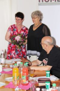 Die Gastgeberin erhält einen Strauß Blumen